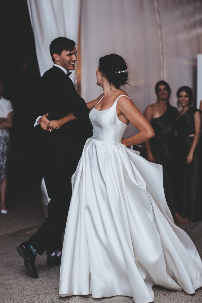 Groom Dancing with Bride Wearing Modern Satin Wedding Gown Called Selena by Maggie Sottero