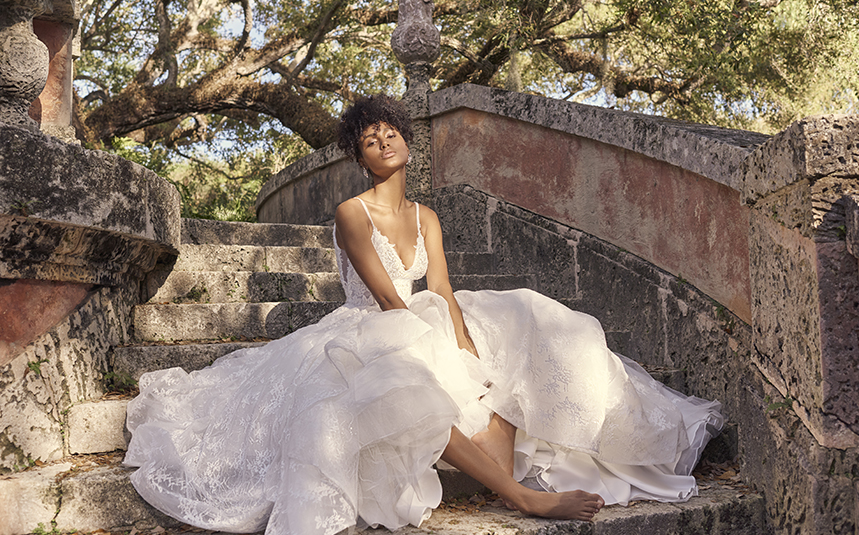 Bride Sitting on Steps Wearing Modern Princess Wedding Dress Called Yuri by Maggie Sottero