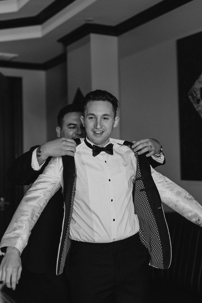 Black And White Photo Of Groom Getting Ready With Groomsmen