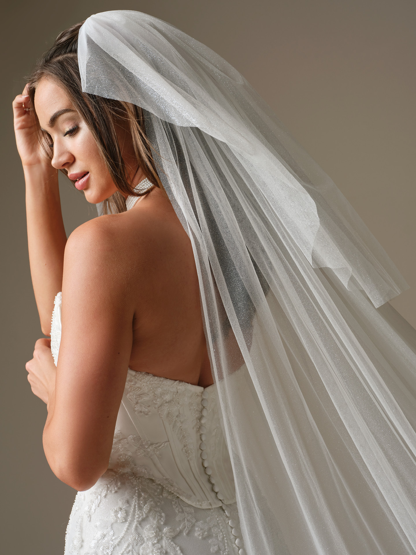 Bride wearing Maggie Sottero Essentials Edit Veil blusher veil paired with a strapless lace wedding dress, side view.