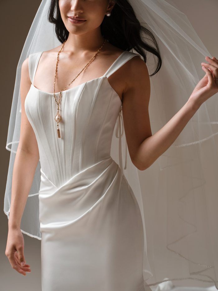 Maggie Sottero Essentials Edit Veil fingertip veil with beaded trim paired with a structured scoop neckline wedding dress, front view.
