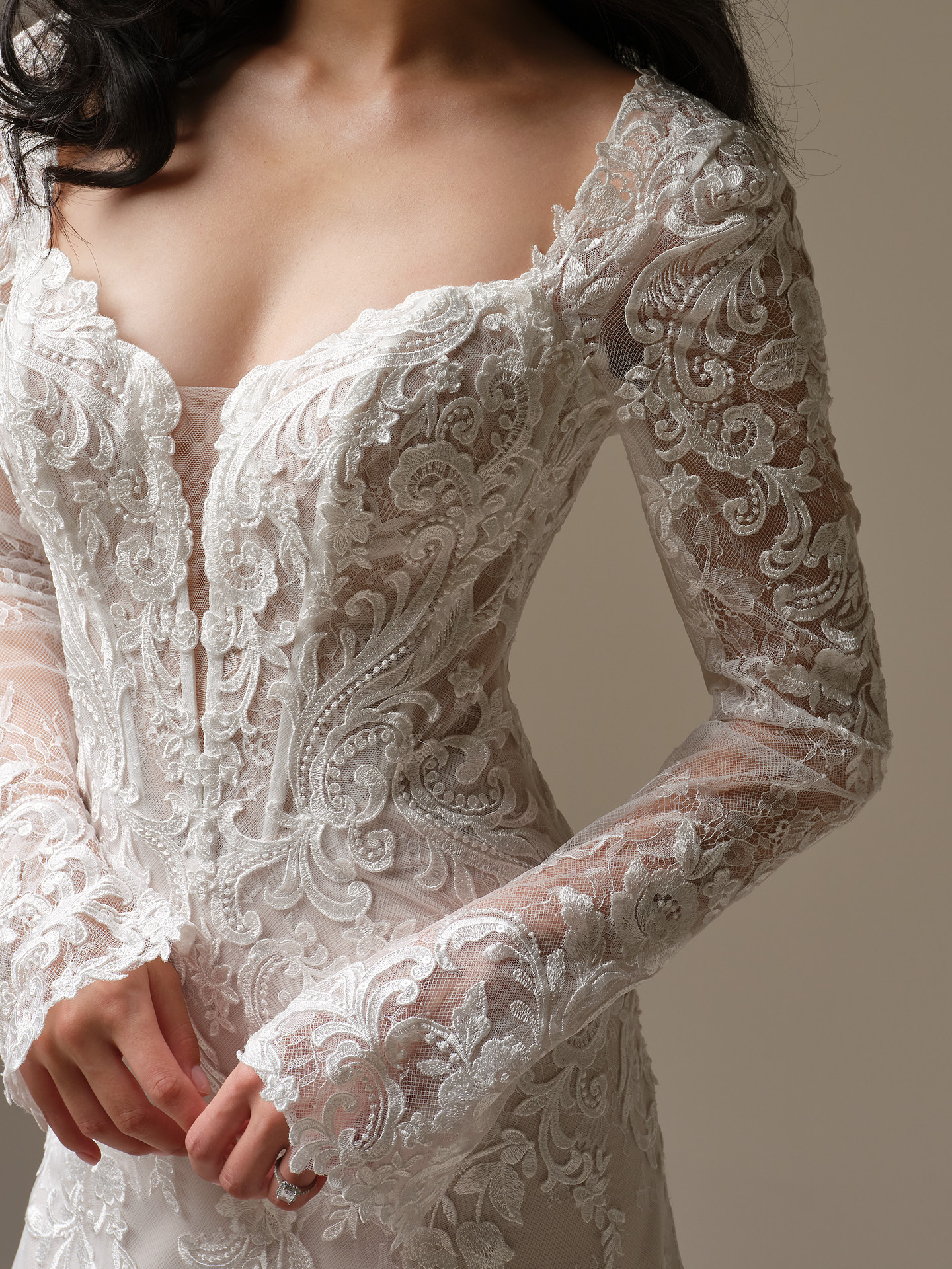 Bride wearing Maggie Sottero Farrah sleeves with lace long sleeves and illusion detail paired with a lace wedding dress, close-up view.