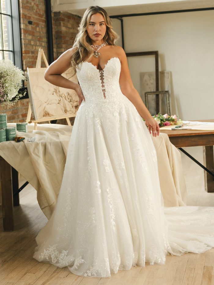 Jennifer ballgown wedding dress featuring a strapless sweetheart neckline, deep illusion plunge, floral lace bodice, and sparkled tulle skirt captured in a romantic studio setting.