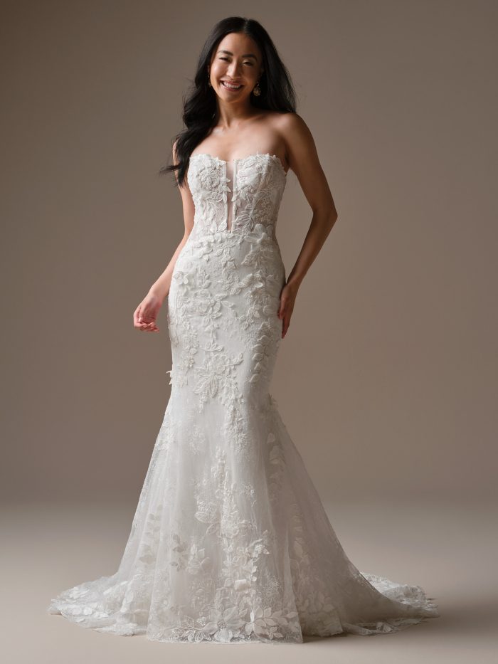 Bride wearing Maggie Sottero Laurie fit and flare wedding dress 26MK428A01 strapless lace wedding dress with floral lace appliqués, full-length view.
