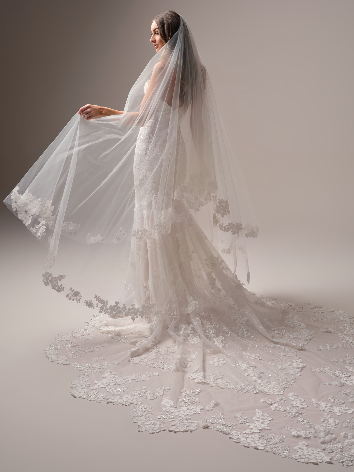Bride wearing Maggie Sottero Malone veil with lace appliqué cathedral veil and blusher paired with a fitted lace wedding dress, side view.