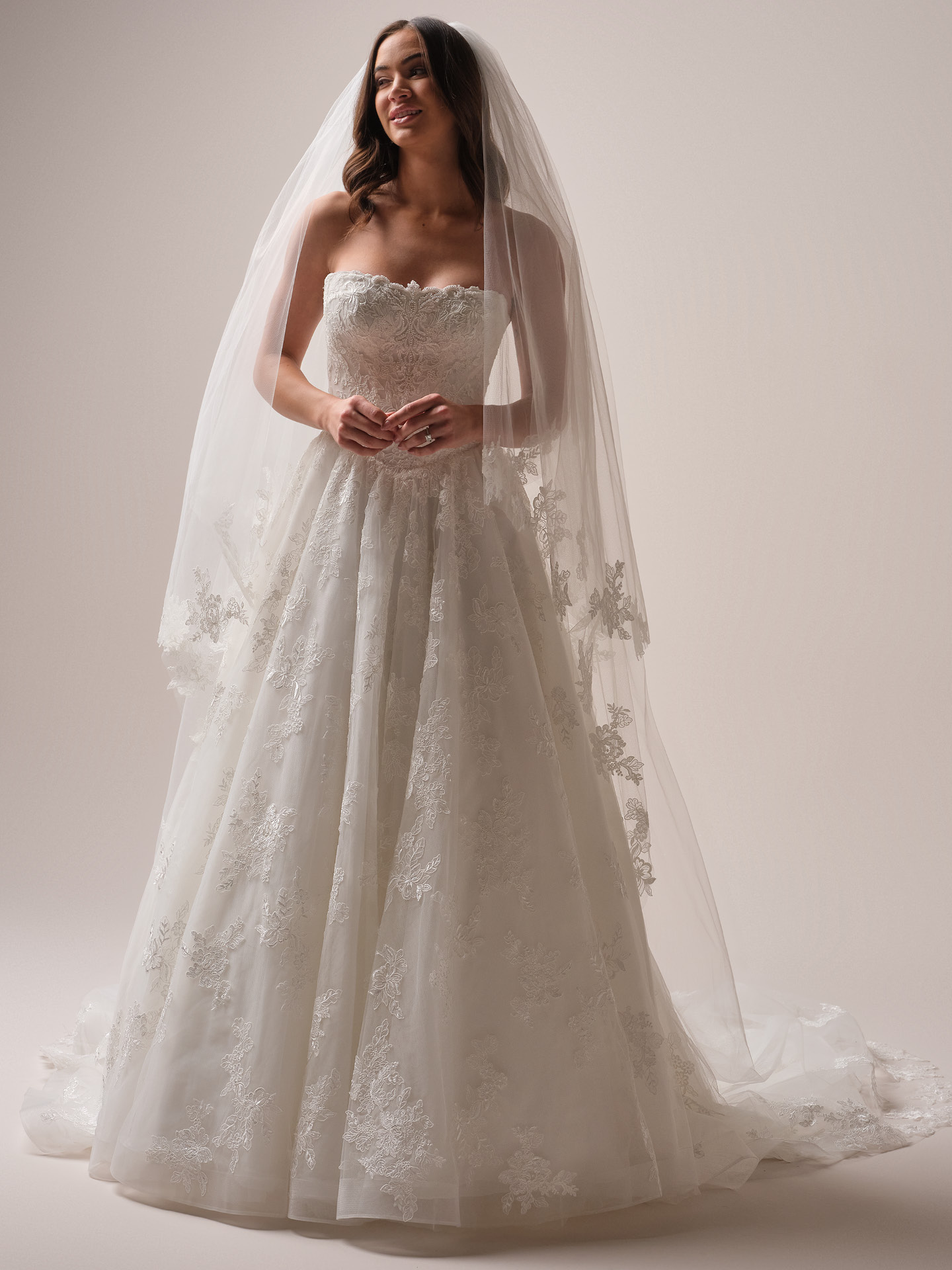 Bride wearing Maggie Sottero Prescott veil with lace cathedral veil and blusher paired with a strapless lace A-line wedding dress, front view.