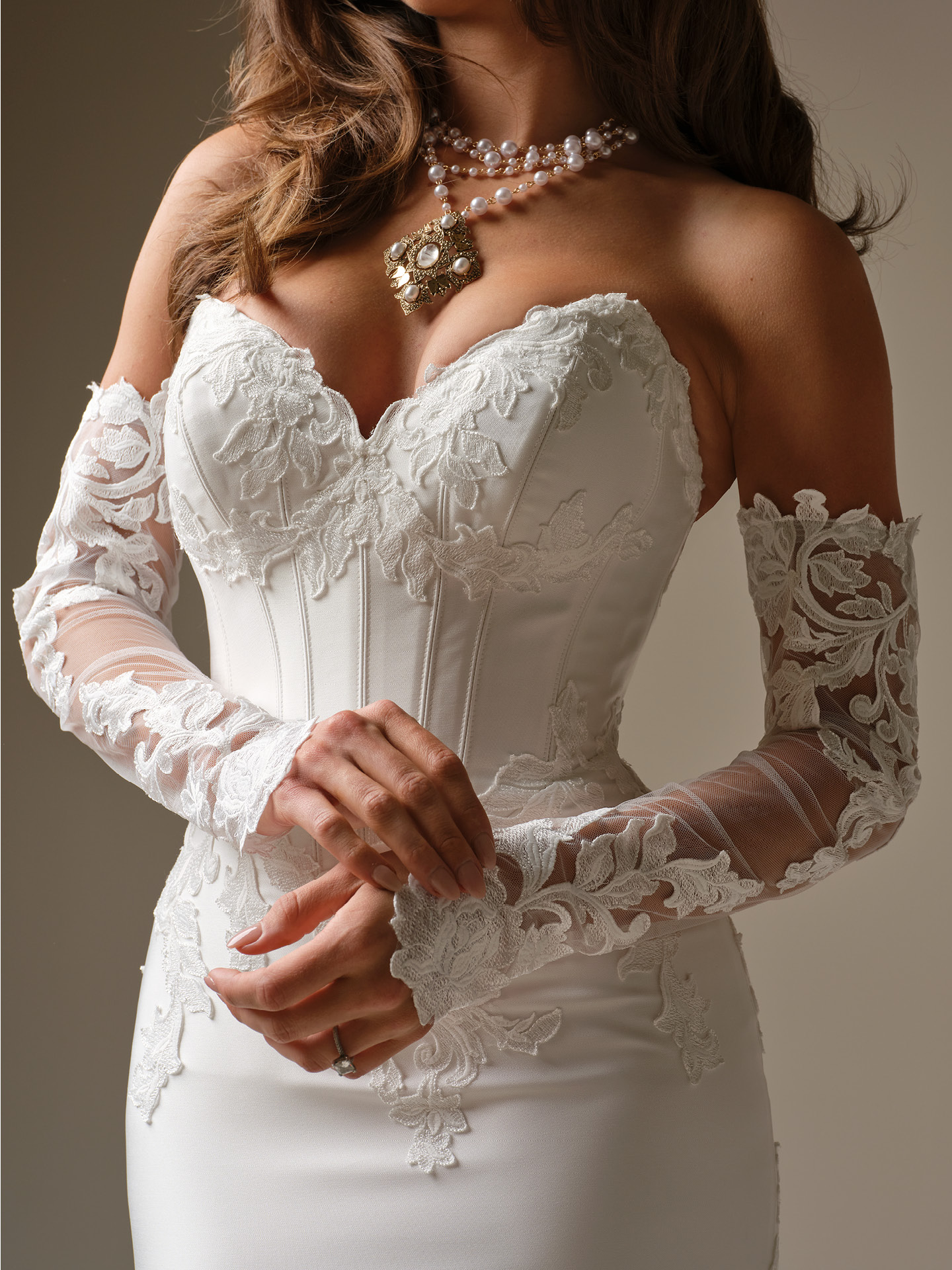 Bride wearing Maggie Sottero Serafina Lane sleeves with off-the-shoulder illusion lace long sleeves paired with a fitted lace wedding dress, close-up view.