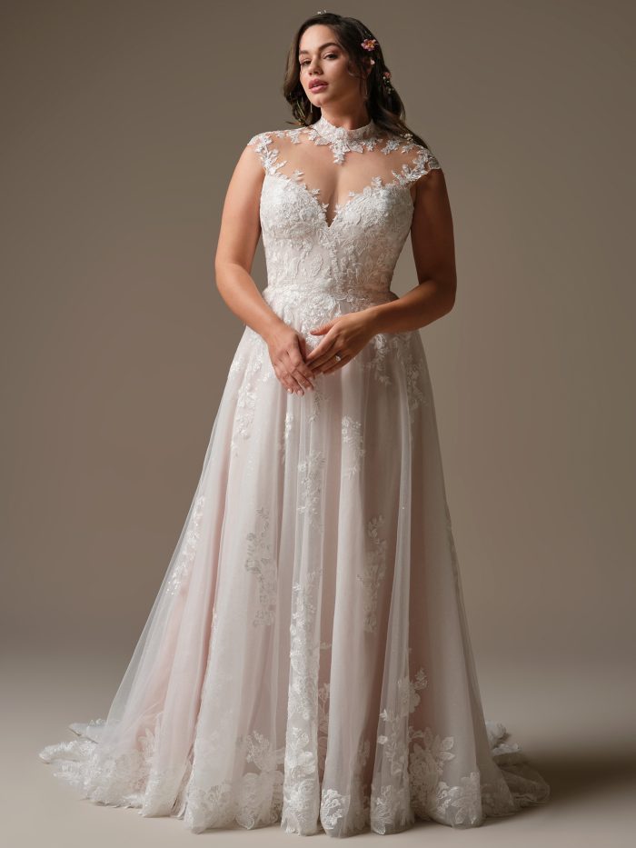 Cody A-line wedding dress featuring a high illusion neckline, floral lace bodice, and soft tulle skirt with lace appliqués in a neutral studio setting.