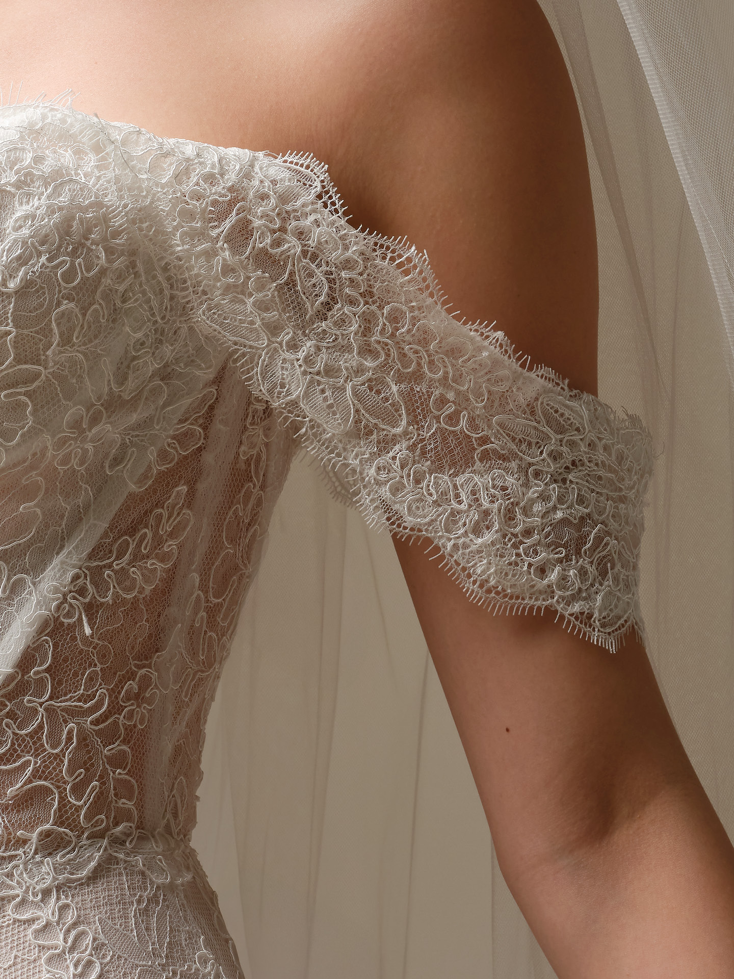 Bride wearing Sottero and Midgley Granger sleeves with off-the-shoulder lace sleeves paired with a lace wedding dress, close-up view.