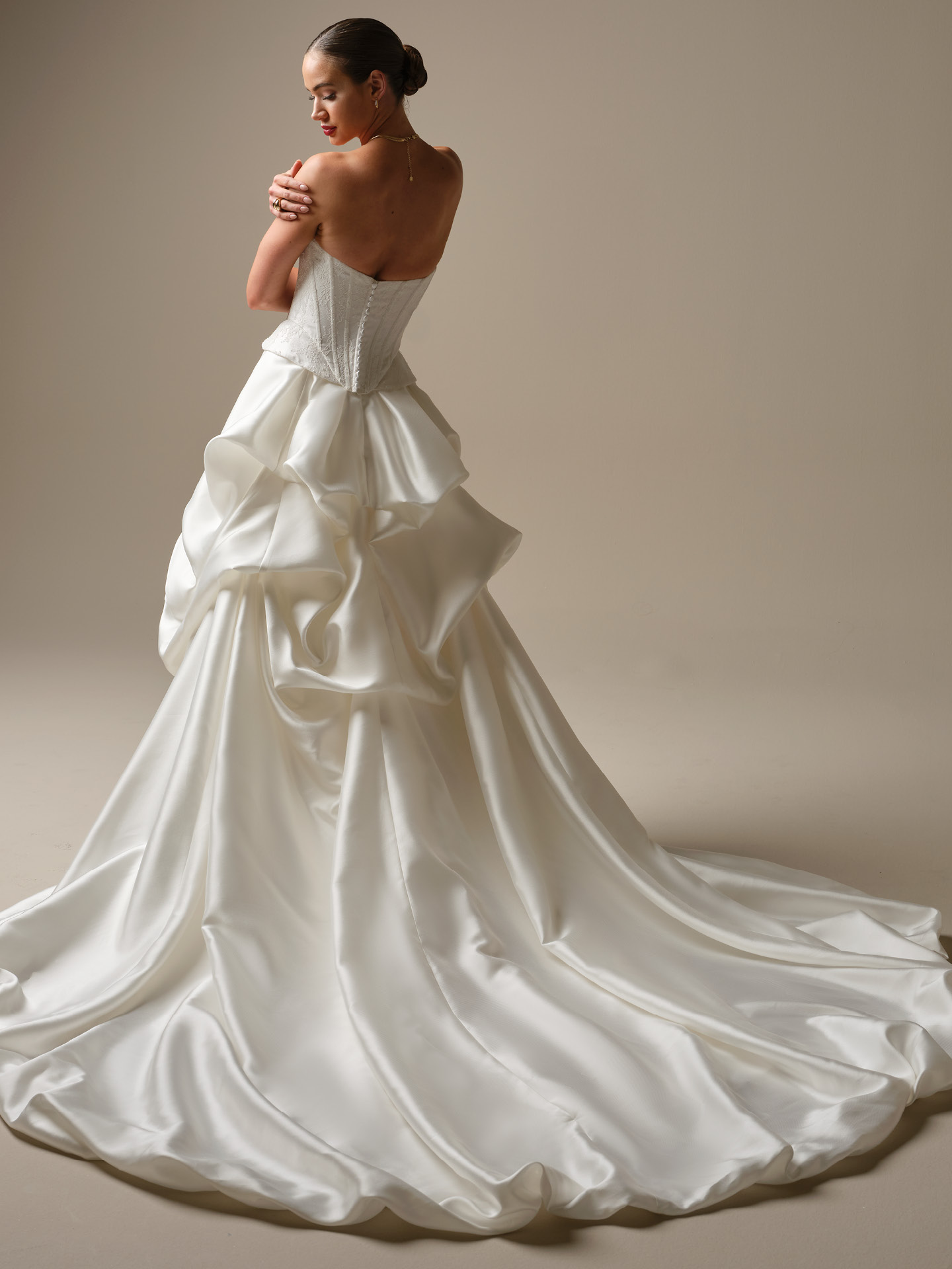 Bride wearing Sottero and Midgley Lassen Marie train dramatic satin detachable train over a strapless wedding dress, back view with long flowing train.