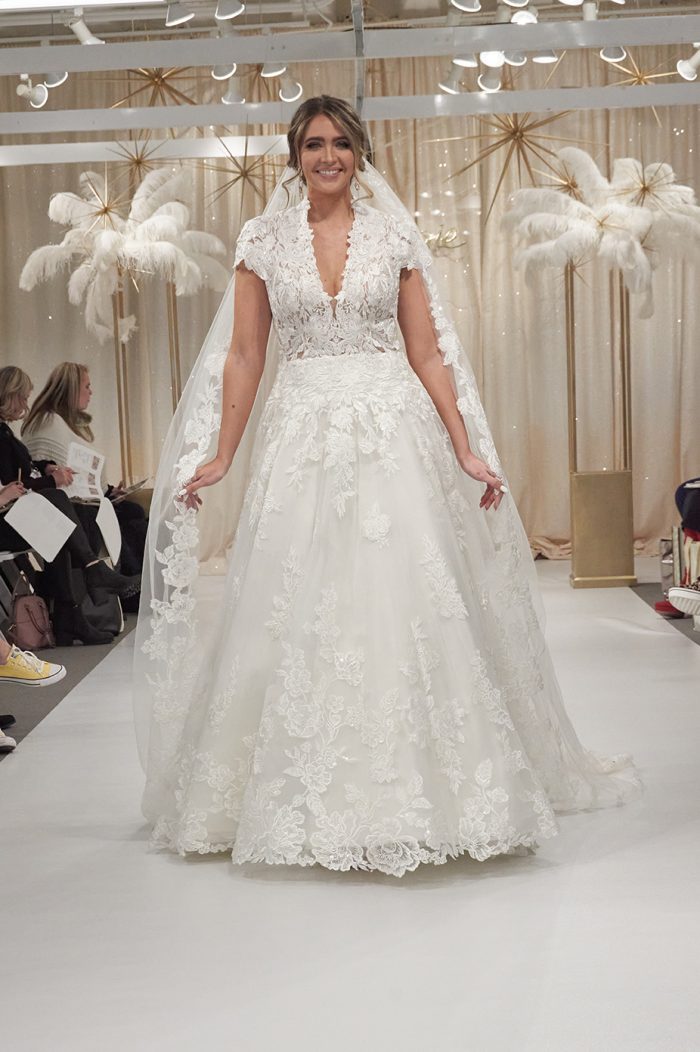 Model Wearing Lacy Cap Sleeve Wedding Dress With Veil Called Kingsley By Sottero And Midgley