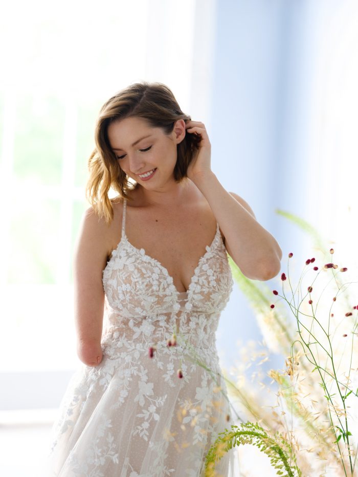 Woman In Wedding Dress Posing Next To Flowers