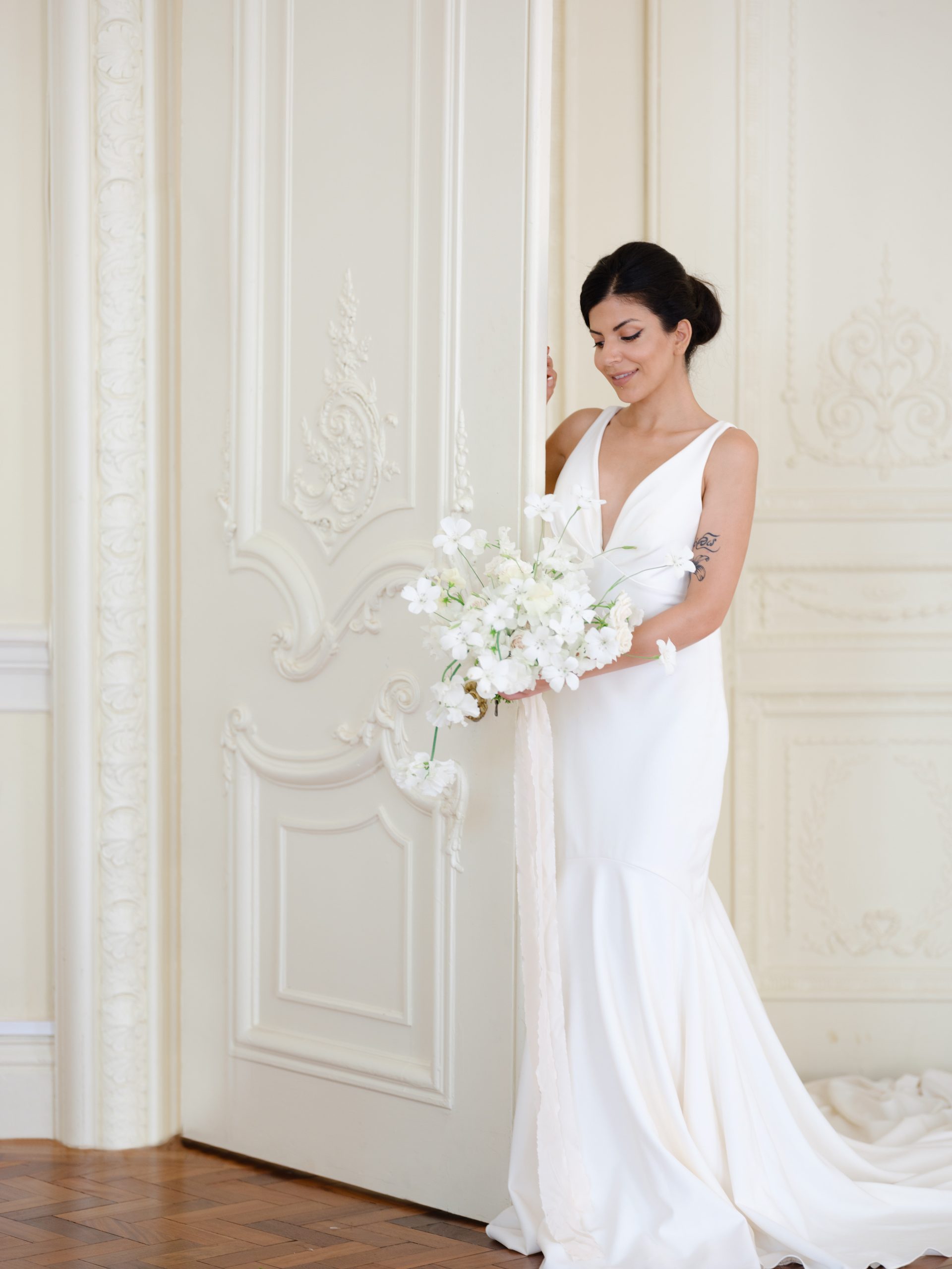 Femme en robe de mariée posant avec des fleurs