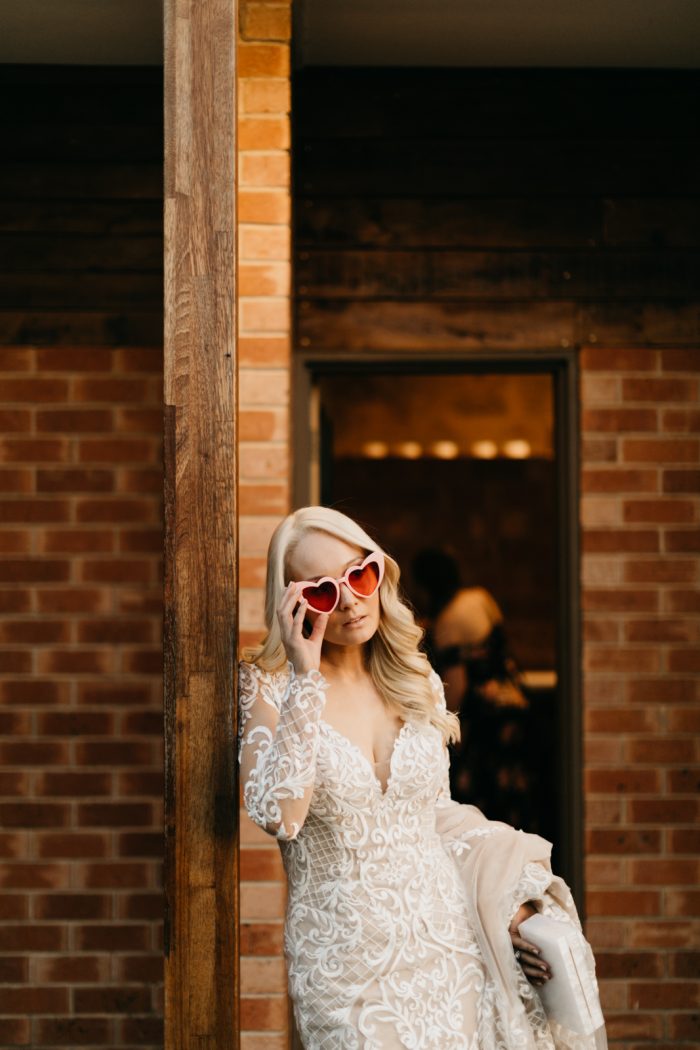 Bride In Long Sleeve Lace Wedding Dress Called Dakota By Sottero And Midgley With Heart Sunglasses