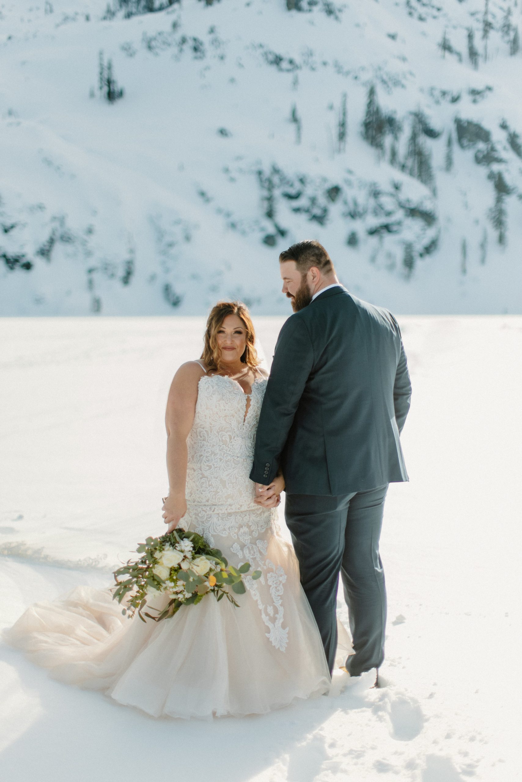 Mariée exhibant sa robe dans la neige dans une robe appelée Allistaire Lynette par Maggie Sottero
