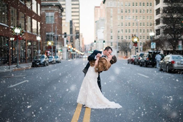 Bride Wearing Kennedy By Maggie Sottero Kissing Her Groom In The Snow