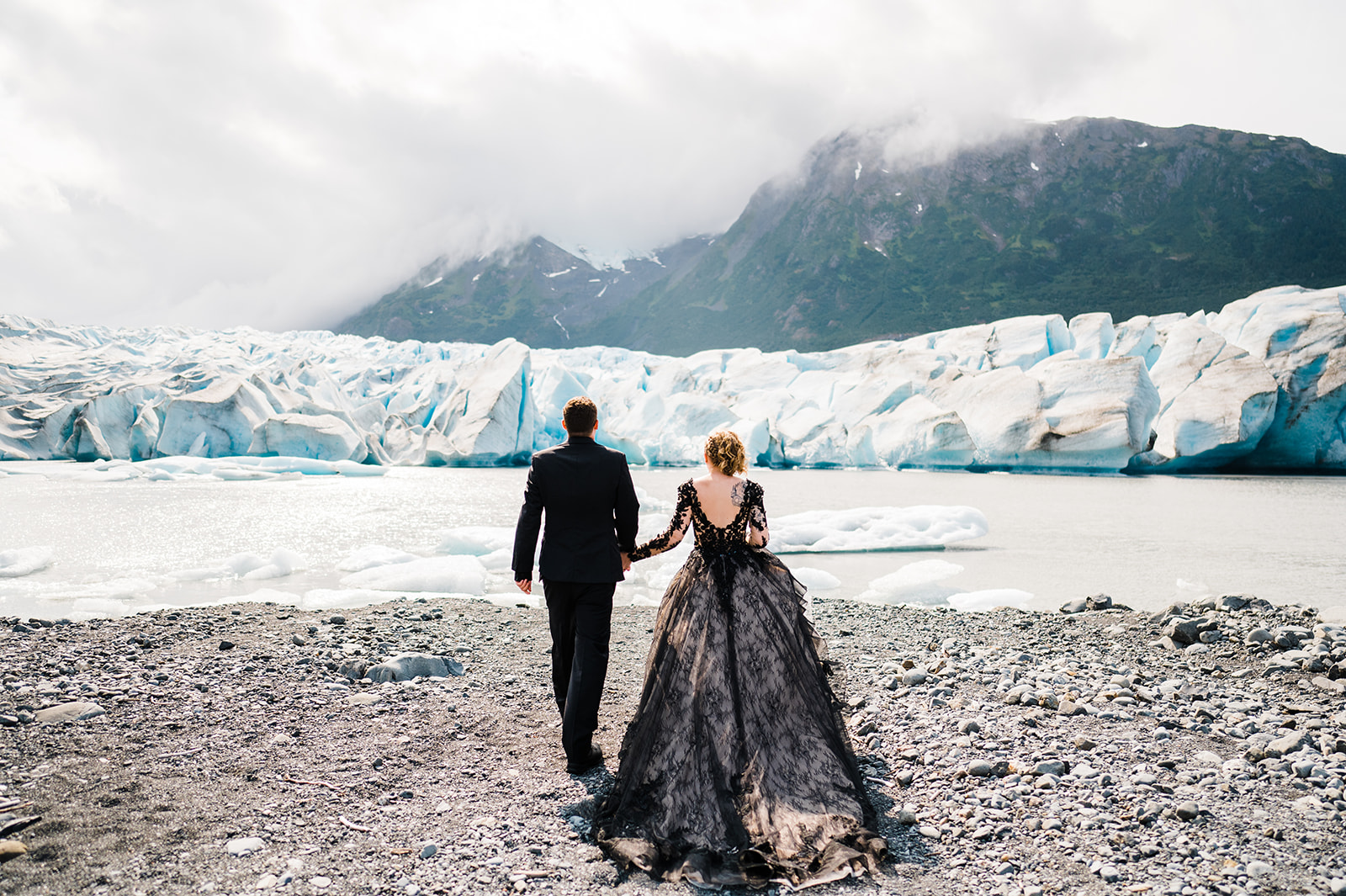 Photographie d'hiver des mariés à Glacier Elopement portant une robe appelée sandre par Midgely et Sottero