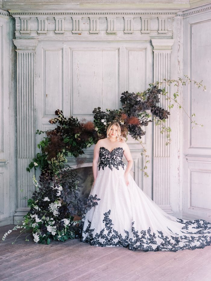 Bride By Flowers And Fireplace Wearing Tristyn By Midgley And Sottero 