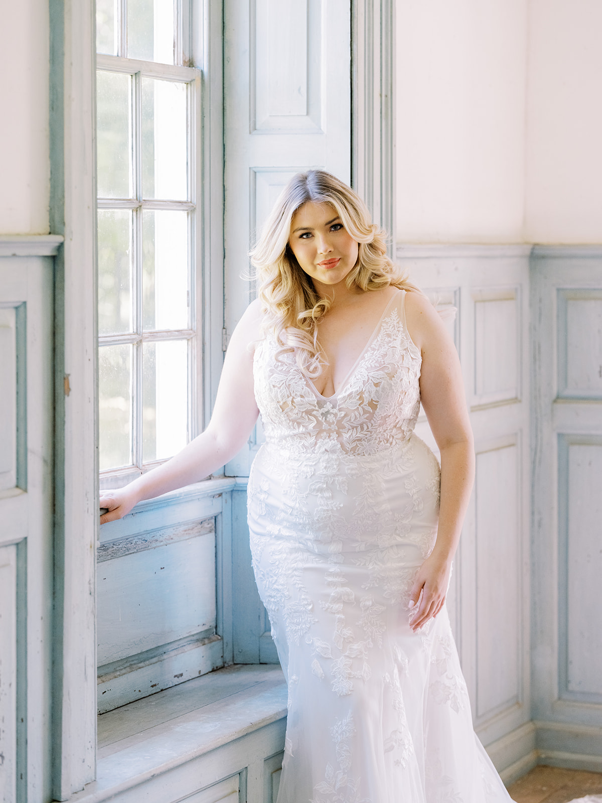 Mariée à côté de la fenêtre portant une robe appelée Greenley par Maggie Sottero 