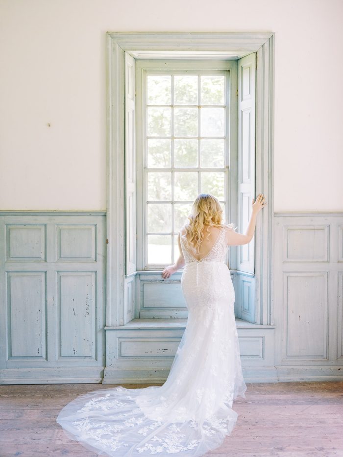 Bride Next To Window Wearing A Dress Called Greenley By Maggie Sottero 