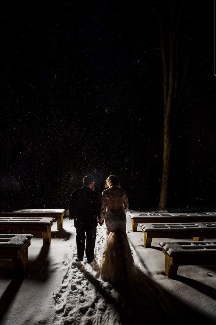 Bride With Groom During Snowfall In A Dress Called Dakota By Maggie Sottero