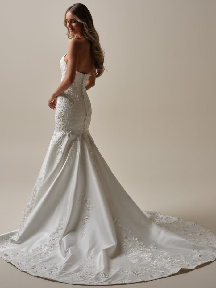 Back view of the Delanie fit-and-flare wedding dress featuring a strapless neckline, covered buttons, and a dramatic lace-accented train.