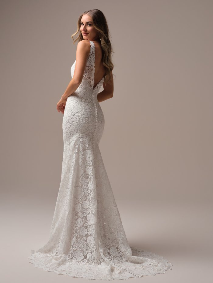 Back view of the Dayna sheath wedding dress featuring a low V-back, scalloped lace straps, and an elegant lace train.