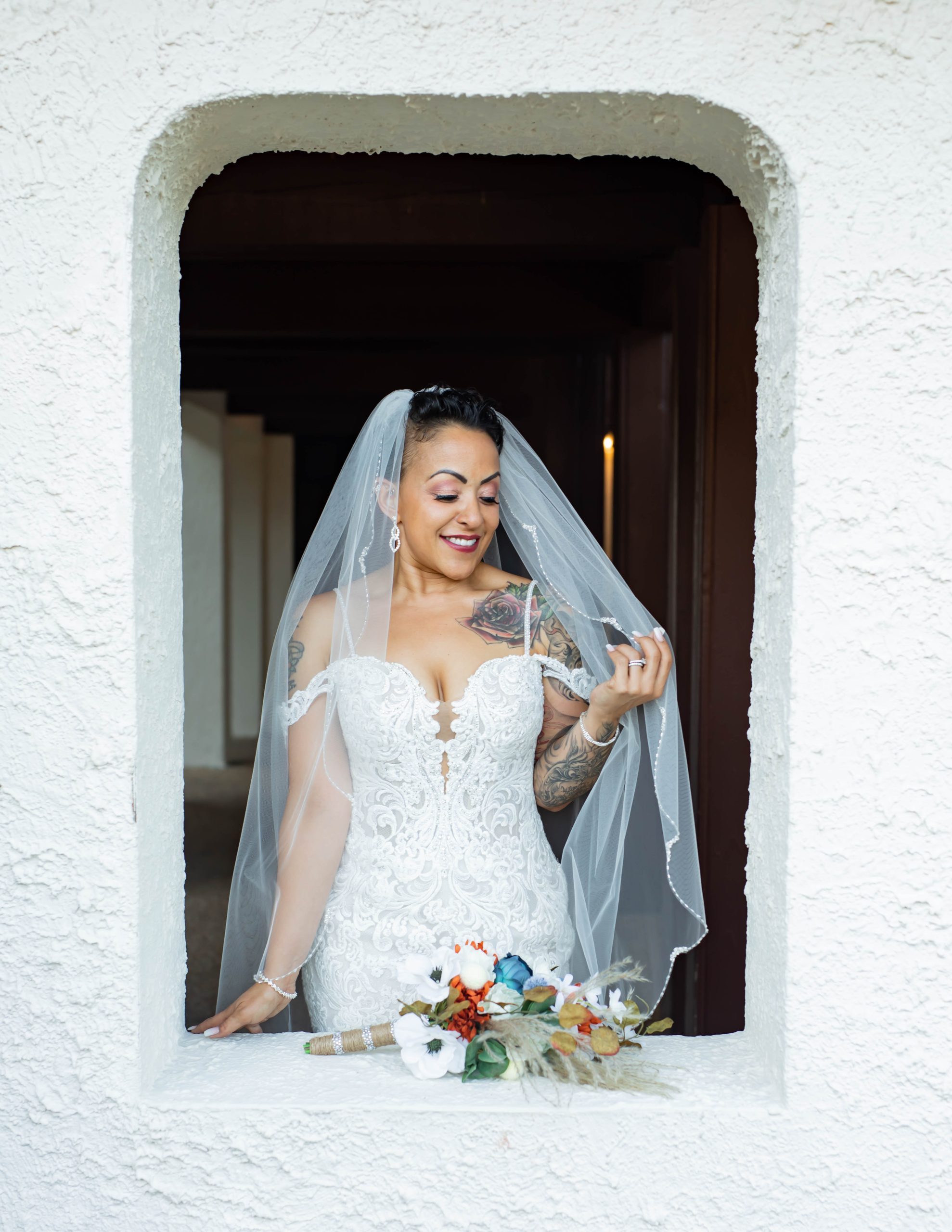 Photo de la mariée portant une robe de mariée en perles appelée Fiona par Maggie Sottero dans la fenêtre