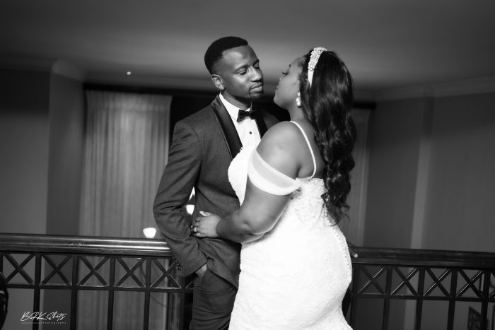 African Bride Wearing A Dress Called Alistaire Lynette By Maggie Sottero Kissing Her Husband In A Black And White Photo