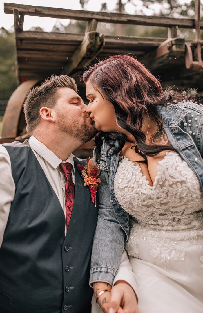 Photo Of Bride In A Jean Jacket Wearing A Dress Called Savannah By Maggie Sottero Kissing Her Husband
