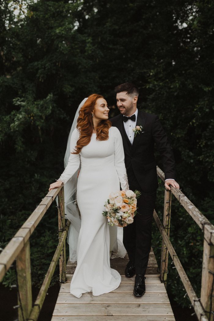 Bride With Red Hair Kissing Husband While Holding A Bouquet With Spring Wedding Colors Wearing A Wedding Dress Called Aston By Sottero And Midgley