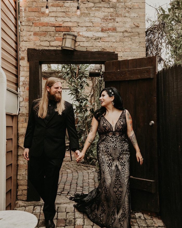 Bride Wearing A Black Wedding Dress Called Elaine By Maggie Sottero Walking With Husband Wearing A Black Suit