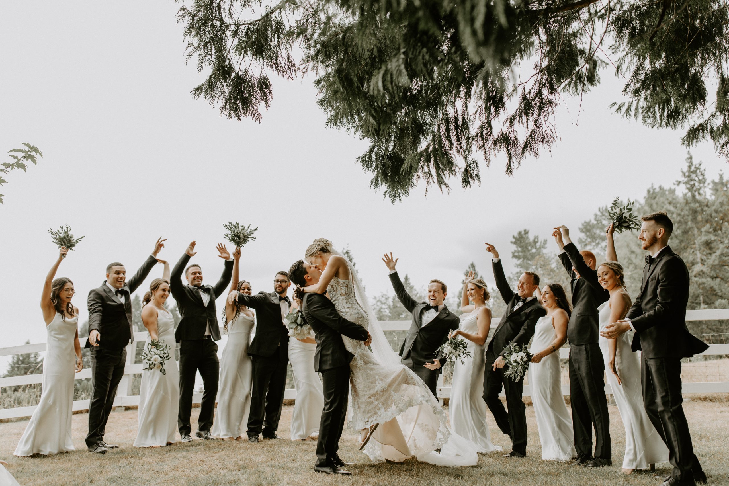 Mariée embrassant son mari vêtu d'une robe de mariée appelée Toscane Lynette par Maggie Sottero avec fête nuptiale dans les couleurs de mariage de printemps