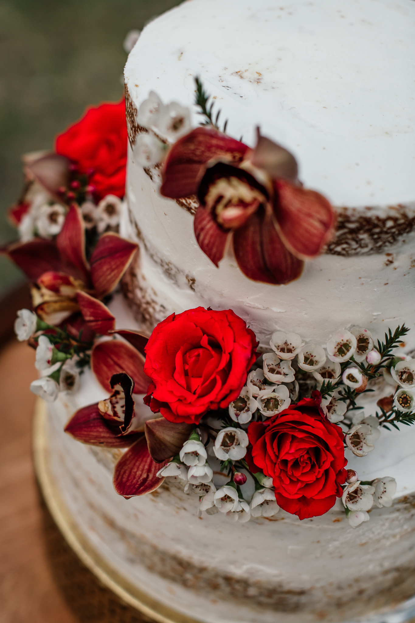 Gâteau de mariage avec des couleurs de mariage de printemps avec des fleurs en rouge et blanc et vert 