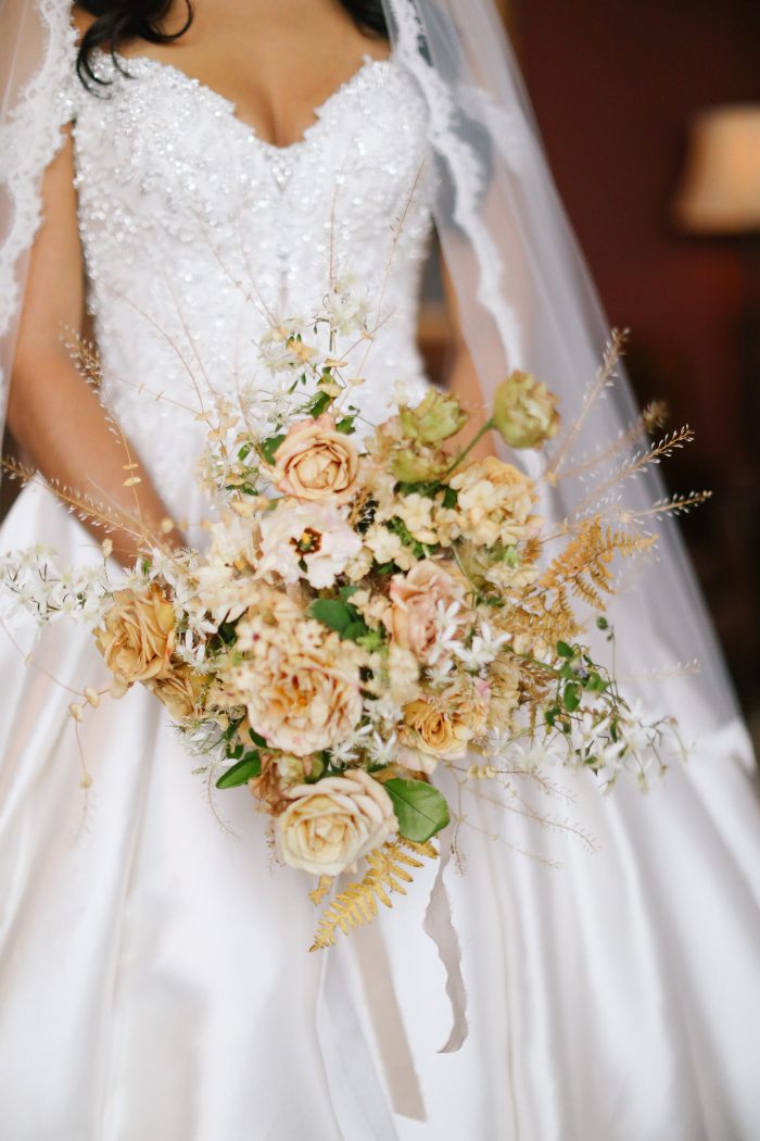 Bride Wearing Beaded Satin Wedding Dress Called Kimora By Sottero And Midgley Holding Flowers