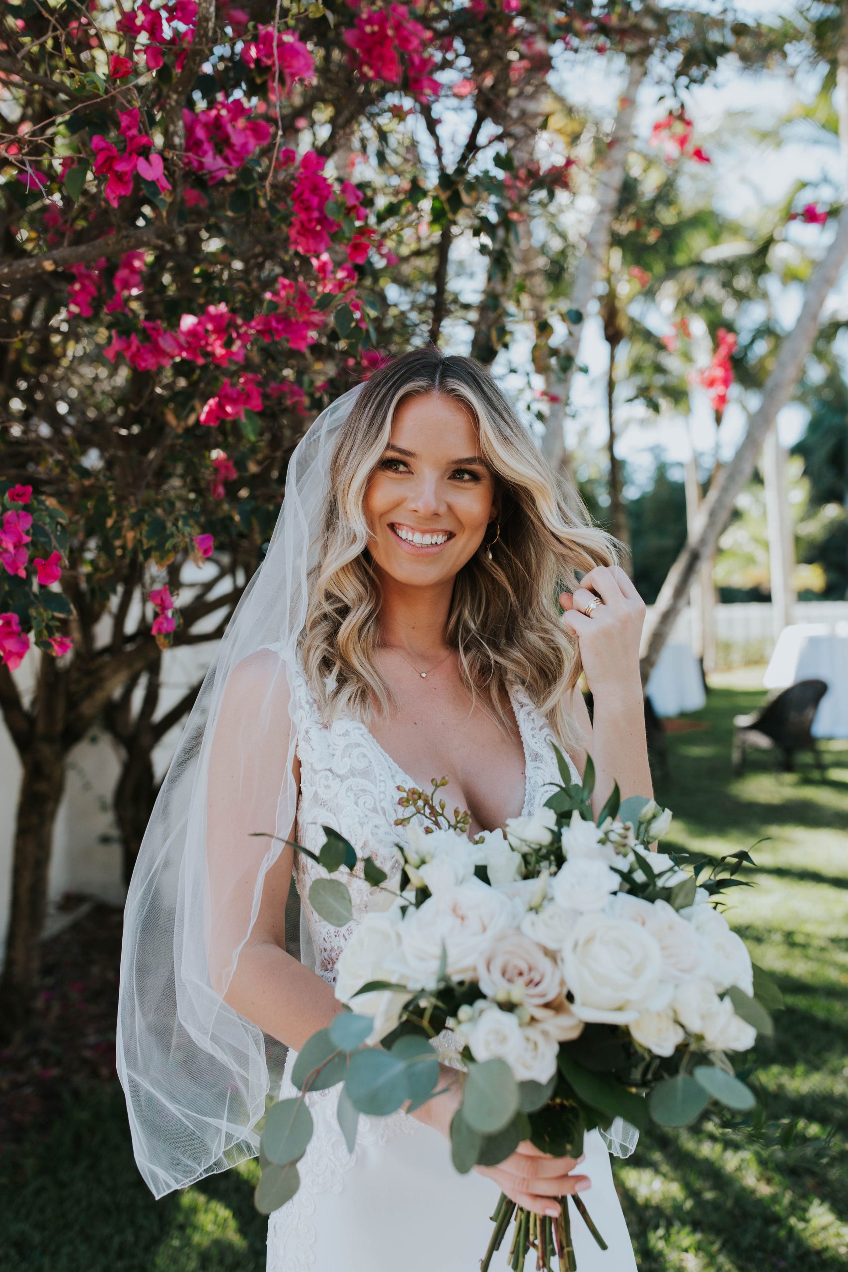 Mariée avec un maquillage de mariage naturel portant une robe de mariée appelée Aidan par Maggie Sottero avec un bouquet de roses blanches