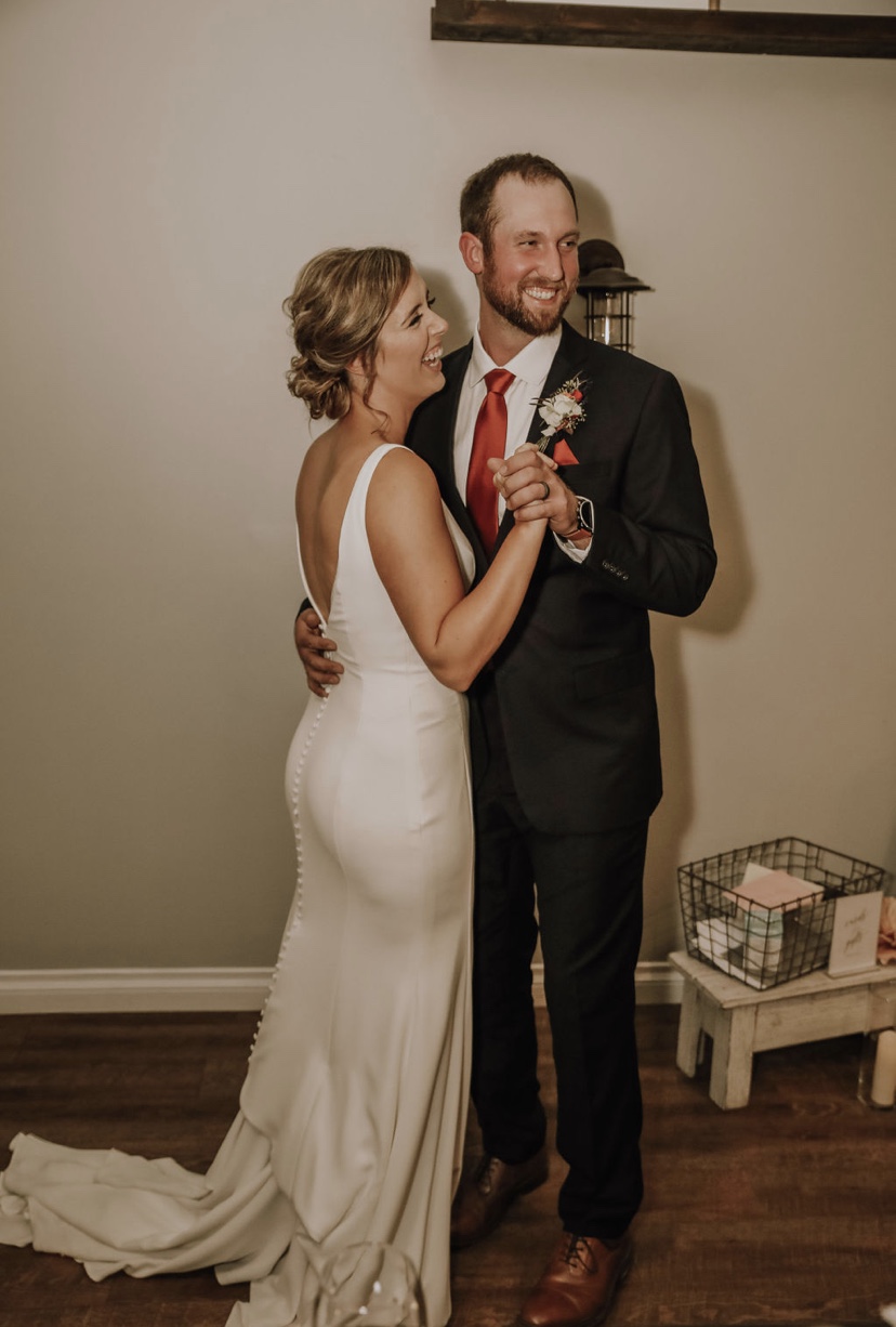 Bride Wearing Sheath Wedding Dress Called Fernanda By Maggie Sottero Standing With Groom At Reception