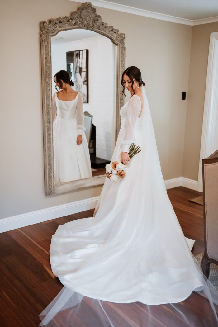 Bride Wearing Satin A-Line Wedding Dress Called Selena By Maggie Sottero In Front Of Mirror