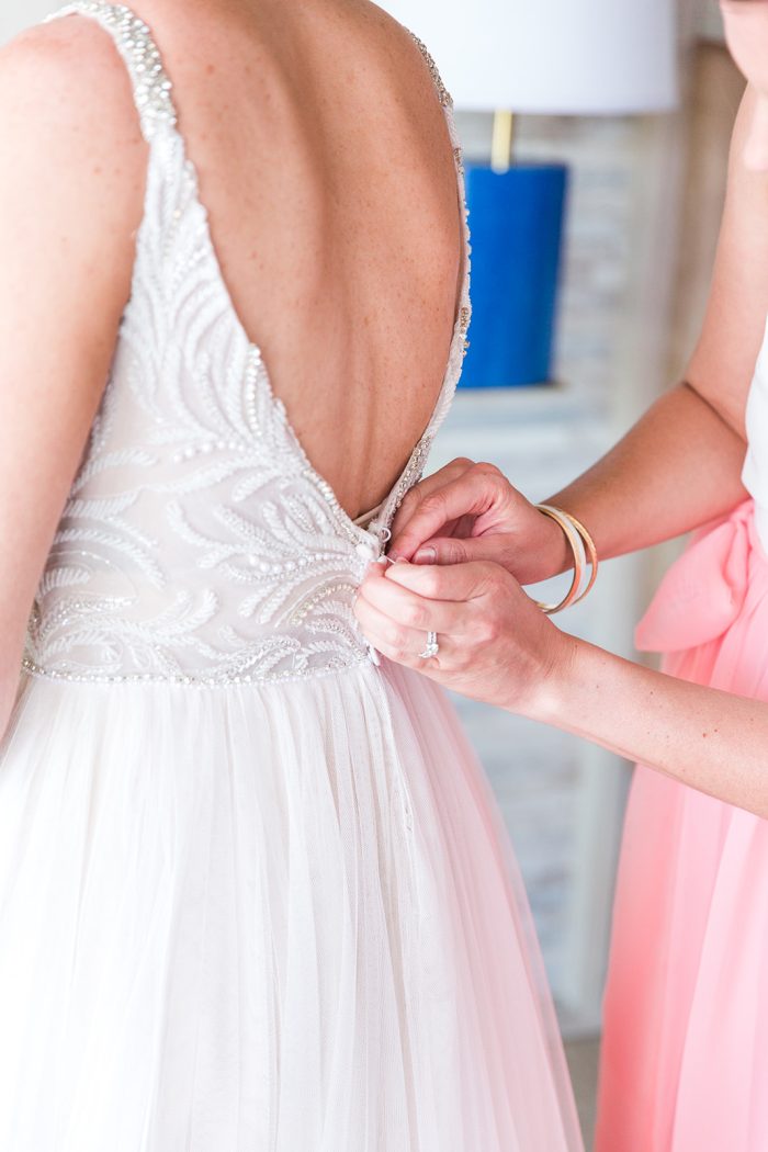 Bride Wearing Wedding Dress Called Charlene By Maggie Sottero With Bridesmaid In Pink Helping Her Get Ready