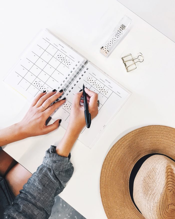 Woman Working In Her Planner To Keep Herself Organized During Mental Health Awareness Month