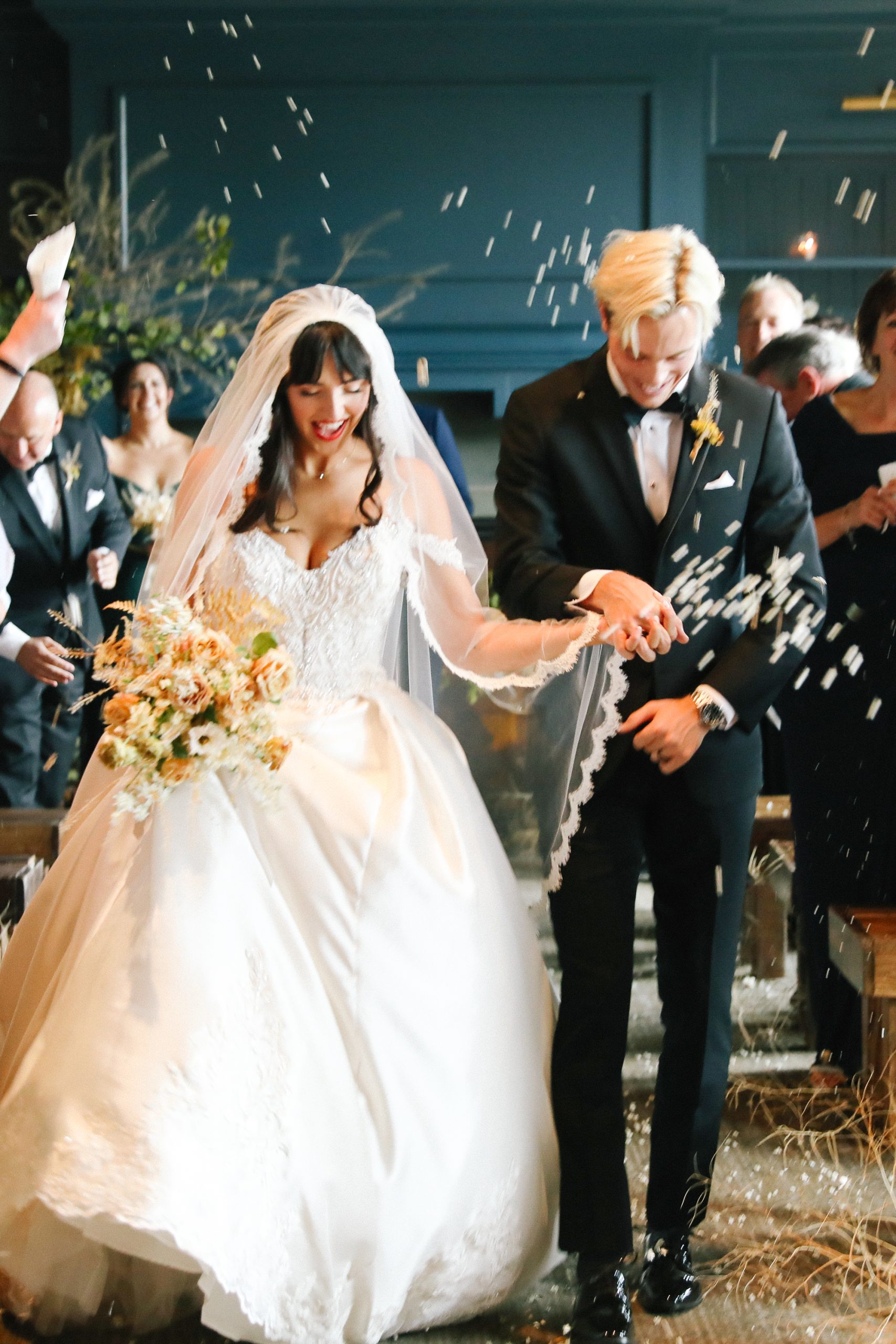 Photo de la mariée portant une robe de bal appelée Kimora par Sottero et Midgley marchant dans l'allée avec le marié avec une fleur envoyer