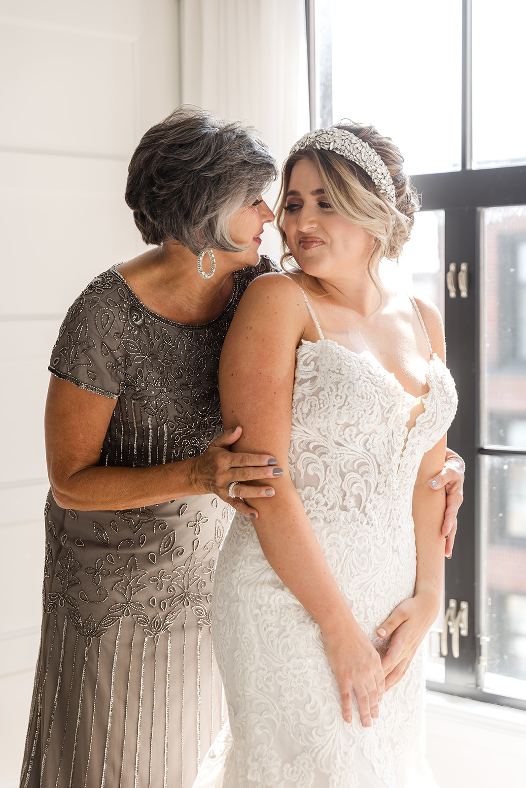 Mariée avec la mère de la mariée dans une robe argentée portant une robe de mariée appelée Alistaire Lynette par Maggie Sottero