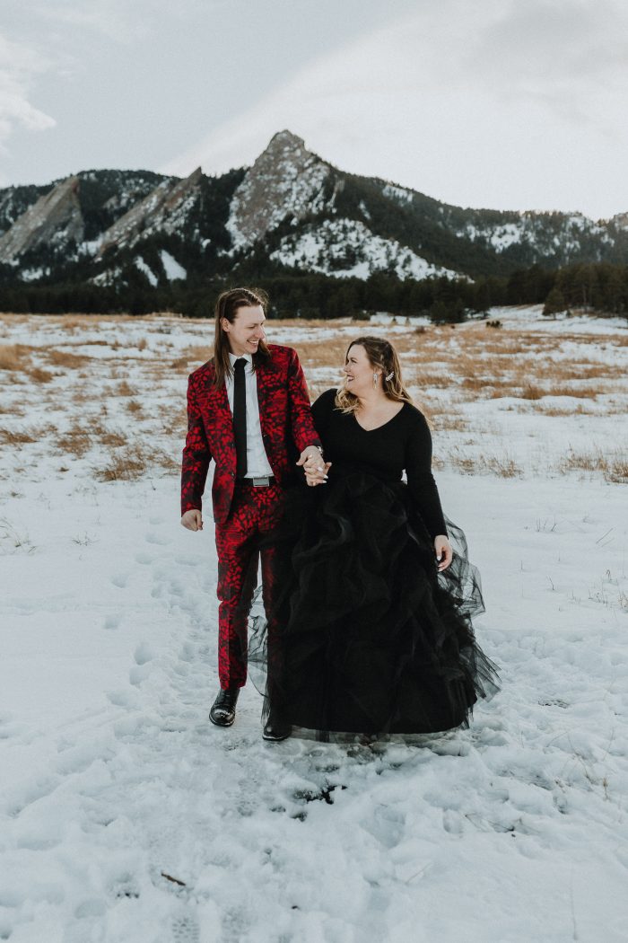 Bride Wearing Black Gown With Fiance In Red Suit During Engagement Photoshoot In Mountains