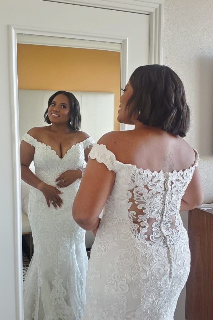 Bride Standing In Front Of Mirror Wearing A Wedding Gown Called Kennedy By Maggie Sottero