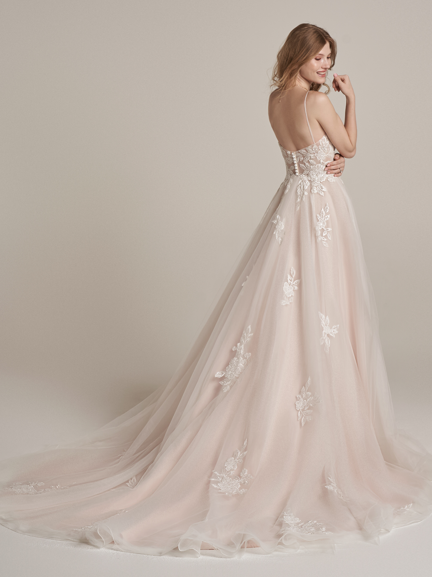 La mariée porte une robe de mariée romantique A-Line appelée Kalina par Rebecca Ingram