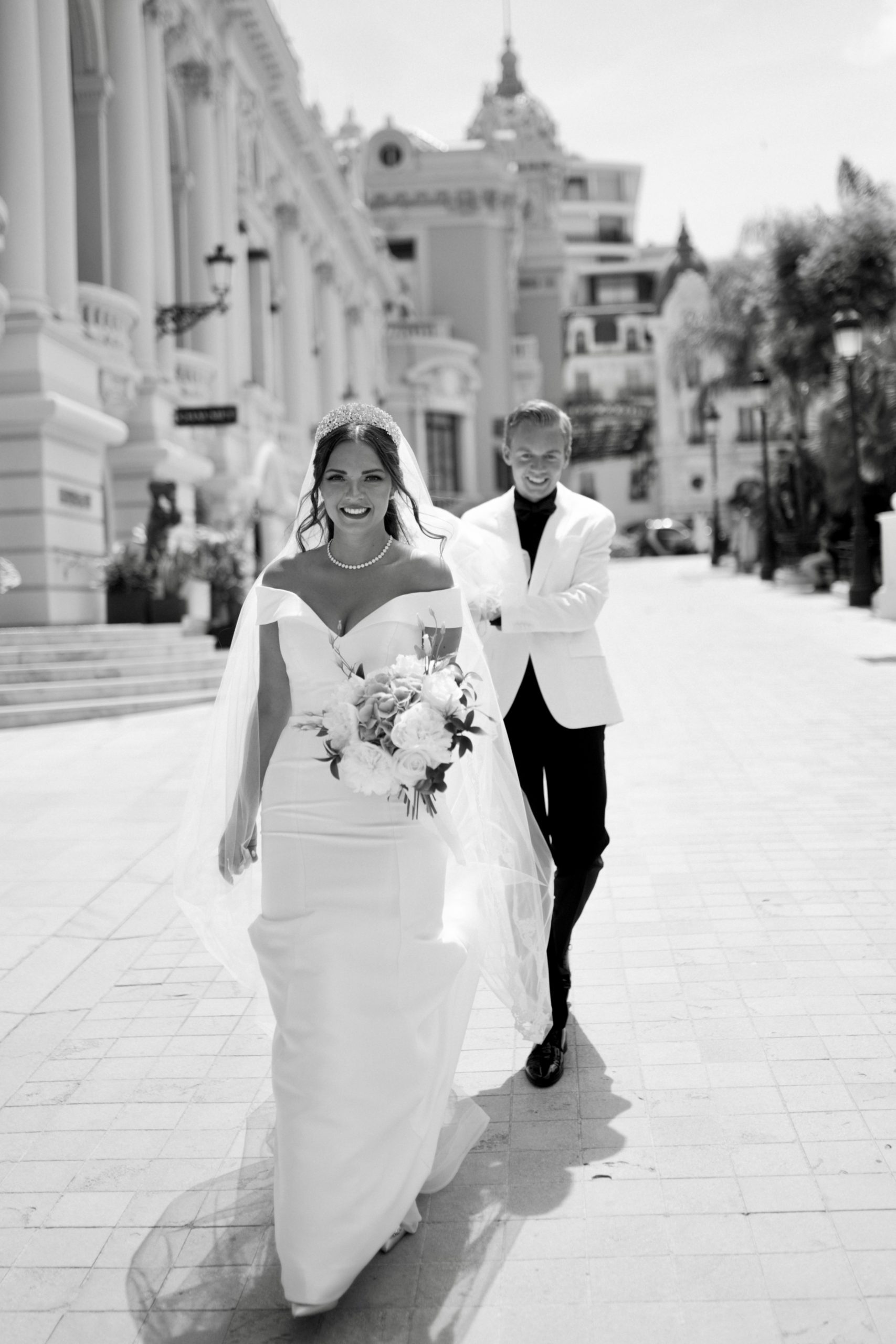 Photo en noir et blanc de la mariée portant une robe de mariée appelée Josie par Rebecca Ingram avec voile et marié