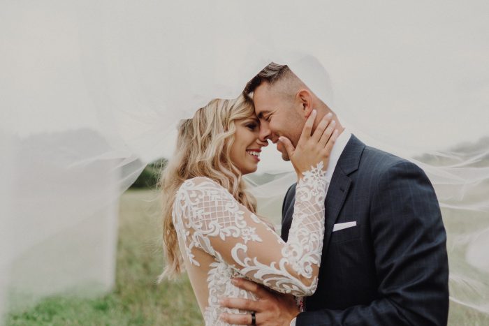 Bride in Long Sleeve Wedding Dress Called Dakota By Sottero And Midgley With Groom And Bridal Veil