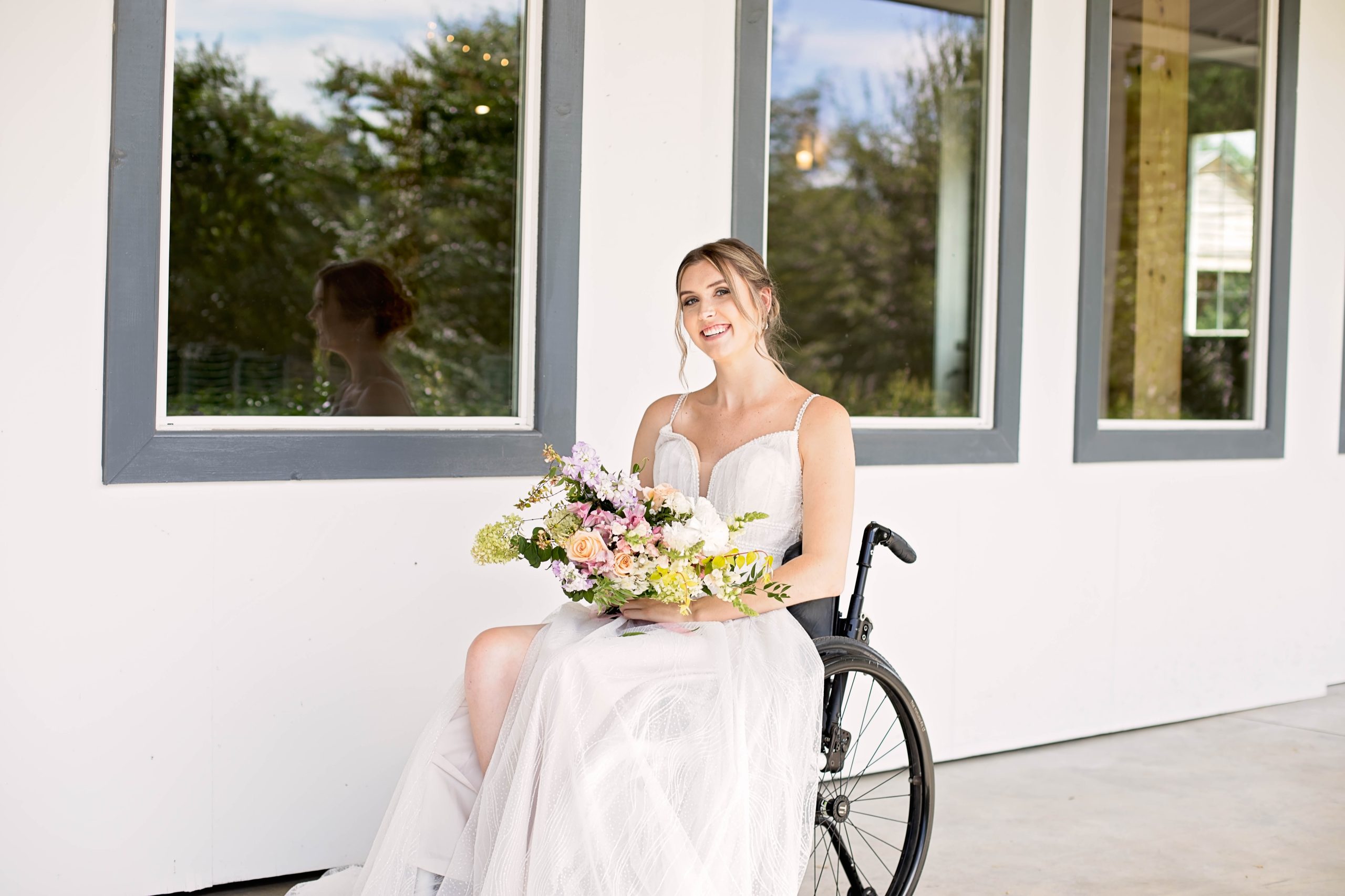 Mariée en fauteuil roulant en robe de mariée A-Line appelée Raelynn par Rebecca Ingram pour tous les corps Toutes les mariées