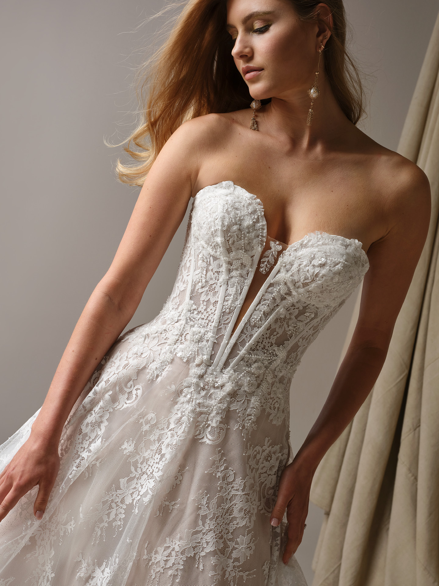 Maggie Sottero Lucca wedding dress close-up showcasing delicate lace motifs, structured bodice with sheer illusion detail, and a flattering, feminine silhouette