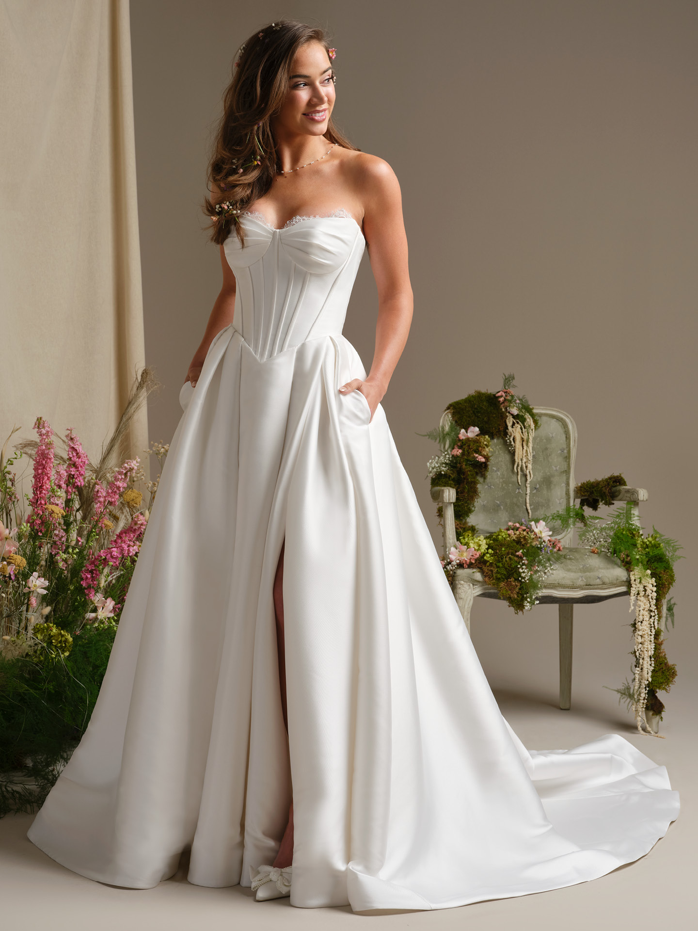 Rebecca Ingram Zorina ballgown wedding dress with strapless sweetheart neckline and structured corset bodice, featuring a full satin skirt with pockets for a romantic, modern bridal look